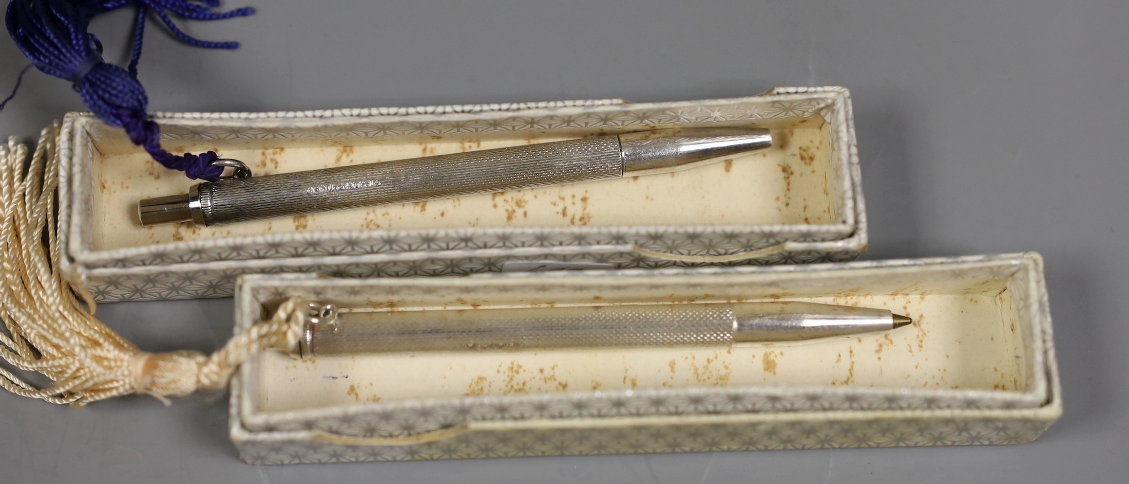 A group of silver and white metal items including a cased boat model, cigar cutter and mounted photograph frame and plated items